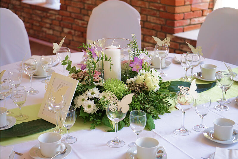 Eventscheune, Tischdekoration. Viel Grün, etwas Weiß. Pinke Akzente.